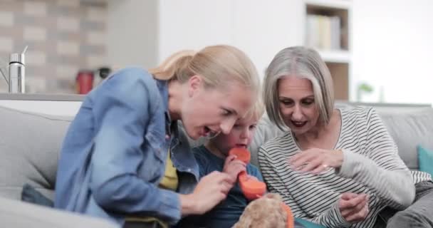 Kind Spelen Met Een Speelgoed Telefoon Met Moeder Grootmoeder — Stockvideo