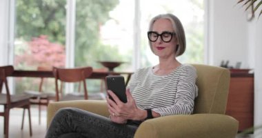 Olgun yetişkin kadın evde bir akıllı telefon kullanma