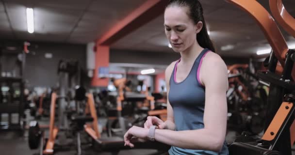 Mujer Comprobando Actividad Rastreador Gimnasio — Vídeo de stock