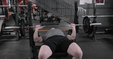 Olgun erkek spor salonunda bench press kullanarak bitirme