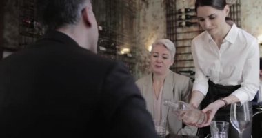 Konuklar restoranda için su dökme garson
