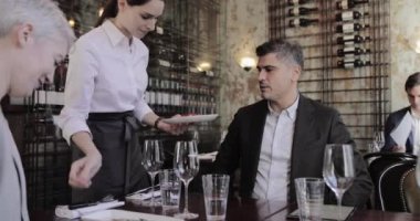 Garson konuklara bir restoranda yemek servisi