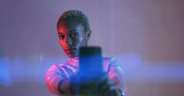 Afro American Feminino em luzes brilhantes coloridas tirando foto com telefone inteligente — Vídeo de Stock