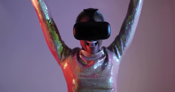 Женщина, использующая технологии виртуальной реальности и празднующая победу — стоковое видео