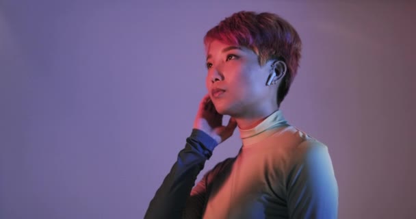 Mujer asiática escuchando música en streaming en auriculares — Vídeo de stock