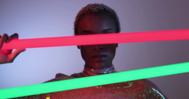 Modelo de alta moda posando com tubos de néon em estúdio — Vídeo de Stock