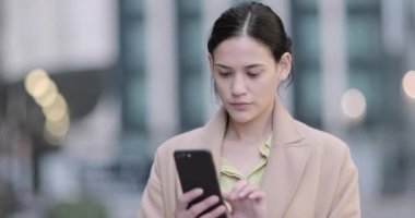İş kadını akıllı telefon kullanarak şehirde açık havada
