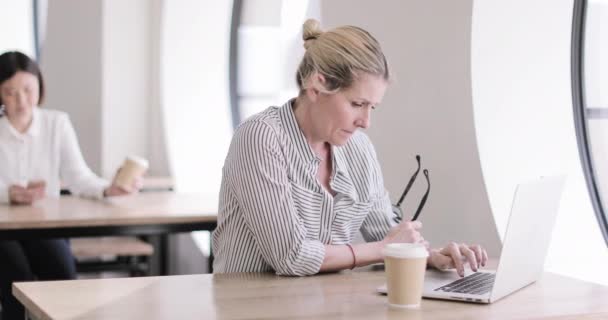 Empresaria en un café usando un portátil — Vídeos de Stock