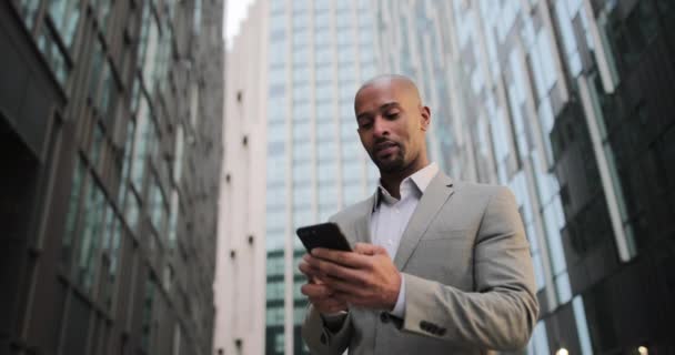 Homme d'affaires marchant dans la ville en utilisant un smartphone — Video