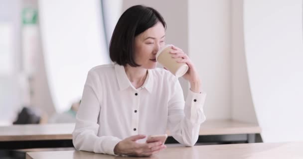 Empresaria en un café usando un smartphone — Vídeos de Stock