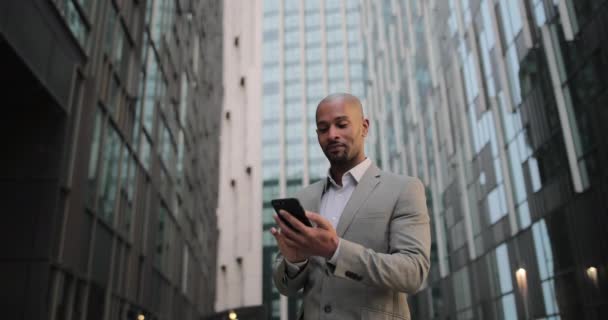 Homme d'affaires marchant dans la ville en utilisant un smartphone — Video