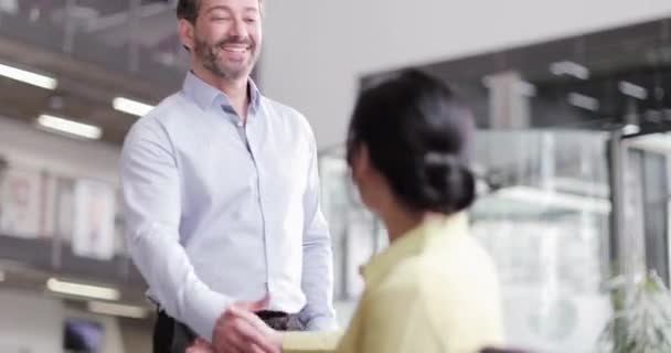 Compañeros de negocios se reúnen y dan la mano — Vídeo de stock