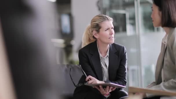 Senior female business executives in a meeting looking at a digital tablet — Stock Video