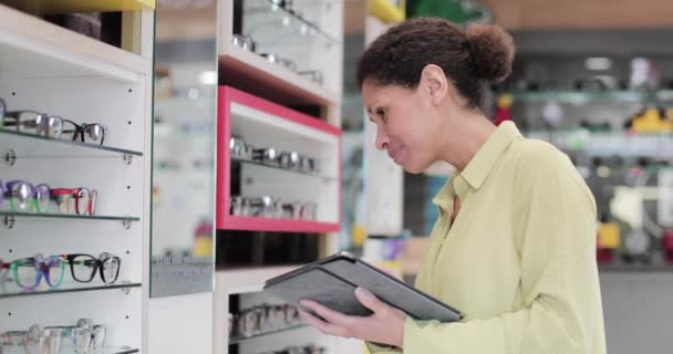 Óptica femenina revisando gafas en la tienda — Vídeos de Stock