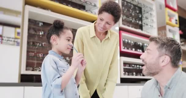 Jeune fille essayer de nouvelles lunettes chez les opticiens — Video