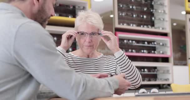 Kunde probiert Rahmen beim Optiker aus — Stockvideo
