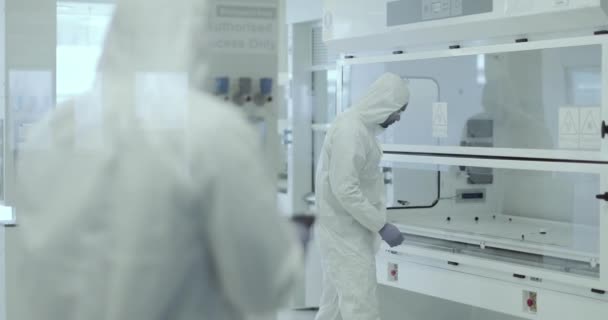 Científicos trabajando en un laboratorio de área de riesgo biológico — Vídeo de stock