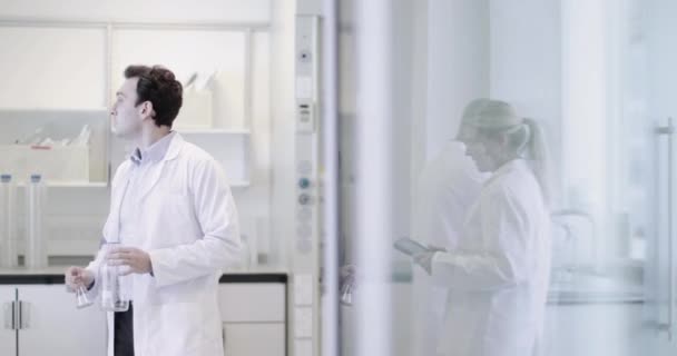 Wetenschappers die in een druk laboratorium werken — Stockvideo