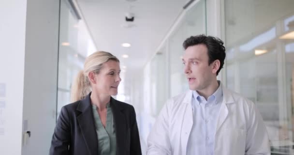 Medic and consultant in a meeting walking through hospital — Stock Video