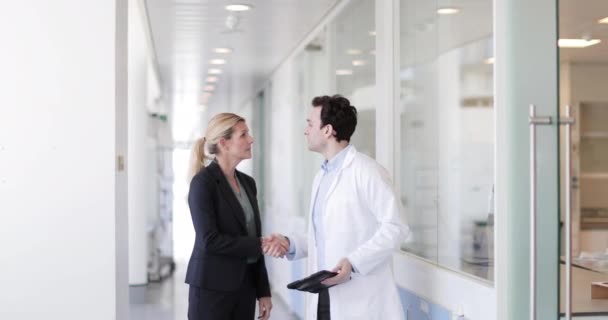 Medic and consultant in a meeting walking through hospital — Stock Video