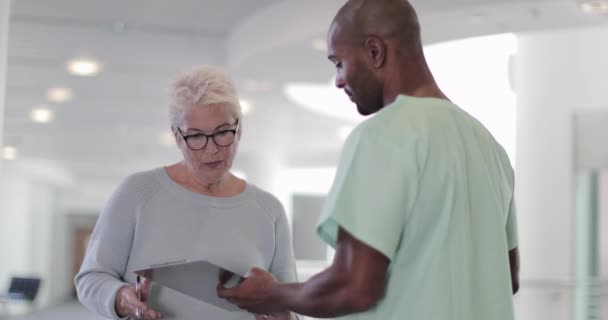 Senior vrouw ondertekeningsformulier in ziekenhuis — Stockvideo