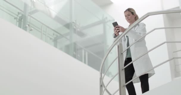 Médico feminino usando smartphone em uma pausa — Vídeo de Stock