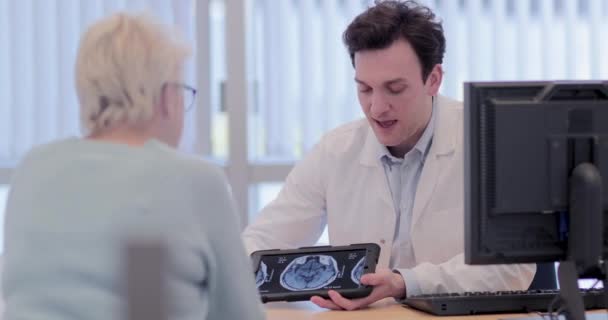 Médico masculino explicando os resultados da varredura para o paciente — Vídeo de Stock