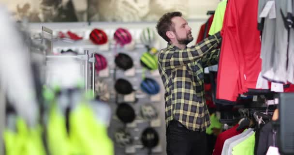 Volwassen man kijken naar sportkleding in de winkel — Stockvideo