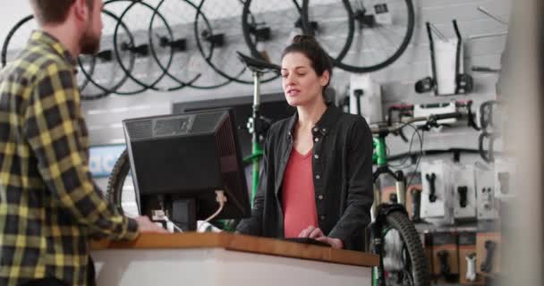 Proprietário da pequena empresa que serve o cliente em uma loja de bicicletas — Vídeo de Stock