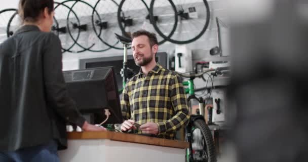 Власник малого бізнесу, що обслуговує клієнта у велосипедному магазині — стокове відео