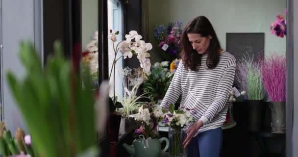 Ενήλικος θηλυκό επιλογή λουλούδια σε ένα ανθοπωλείο — Αρχείο Βίντεο