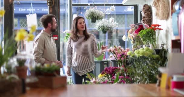 Флорист обслуживает клиента в магазине — стоковое видео