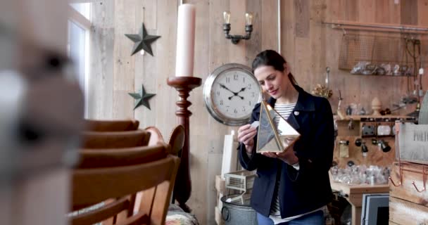 Volwassen vrouw kijken naar prijskaartjes in een vintage antiekwinkel — Stockvideo