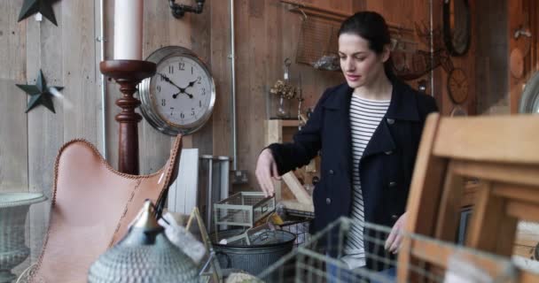 Volwassen vrouw kijken naar prijskaartjes in een vintage antiekwinkel — Stockvideo