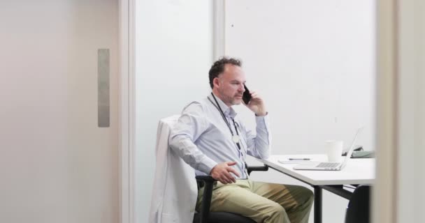 Male Medical Doctor on phone in his office — Stock Video