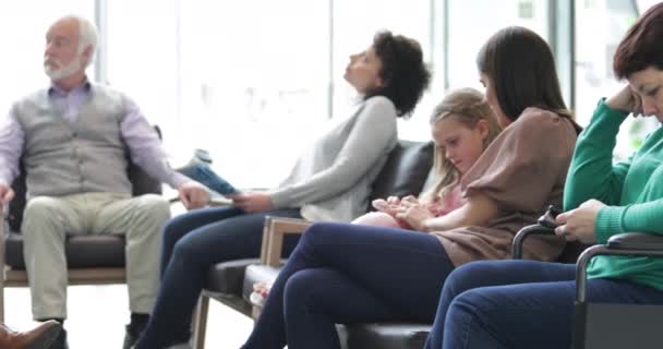 Pacientes esperando en una concurrida sala de espera del hospital — Vídeos de Stock