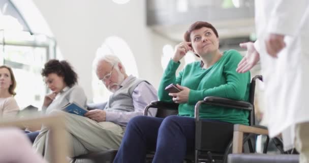 Handikappad kvinna pratar med läkare i väntrum — Stockvideo