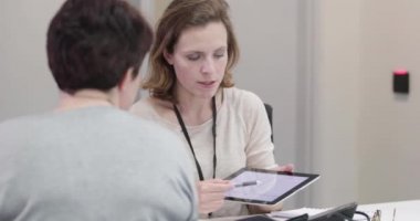 Kadın Tıp Doktoru hastaya test sonuçlarını açıklıyor