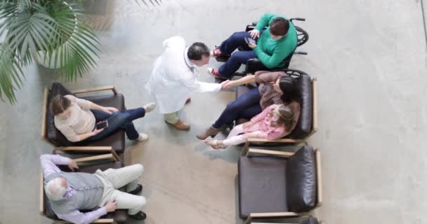 Overhead shot of Medical Doctor greeting Mother and Daughter in waiting room — Stock Video