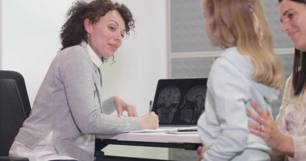 Médico femenino que escribe una receta para un niño — Vídeos de Stock