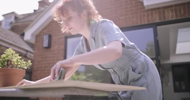 Joven mujer adulta haciendo carpintería DIY en el patio — Vídeo de stock