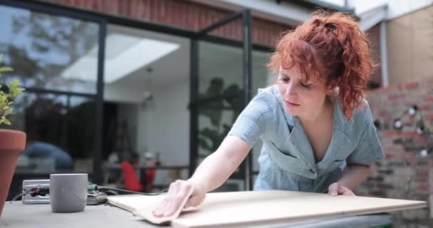 Молодая взрослая женщина делает столярное дело DIY в саду — стоковое видео