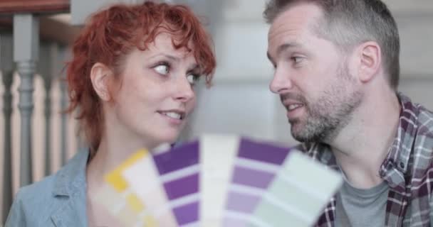 Взрослая пара в новом доме смотрит на образцы краски — стоковое видео