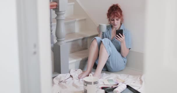 Femme adulte dans une nouvelle maison regardant des idées de décoration sur téléphone intelligent — Video