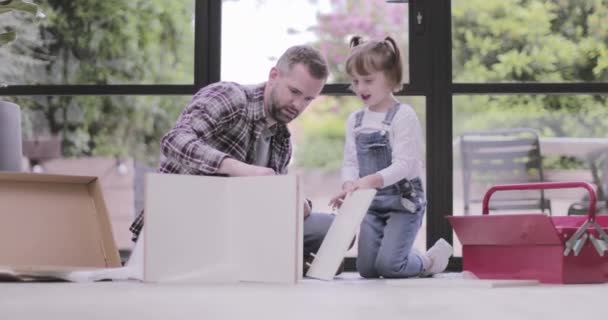 Padre e hija construyendo muebles de paquete plano — Vídeos de Stock