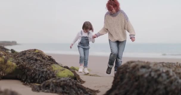 Madre e hija jugando en la playa en primavera — Vídeos de Stock