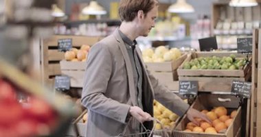 Erkek alışverişçi marketten meyve alıyor.