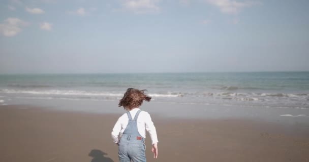 Παιδί τρέχει προς τη θάλασσα στην παραλία — Αρχείο Βίντεο