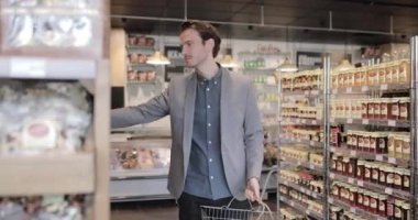 Yetişkin erkek yiyecek pazarında alışveriş yapıyor.