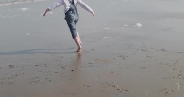 Dítě hrající si na pláži a v moři — Stock video